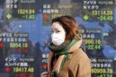 A woman walks by an electronic stock board of a securities firm in Tokyo, Thursday, Dec. 27, 2012. Asian markets have risen amid optimism that Japan’s new leaders will stimulate its sluggish economy. (AP Photo/Koji Sasahara)